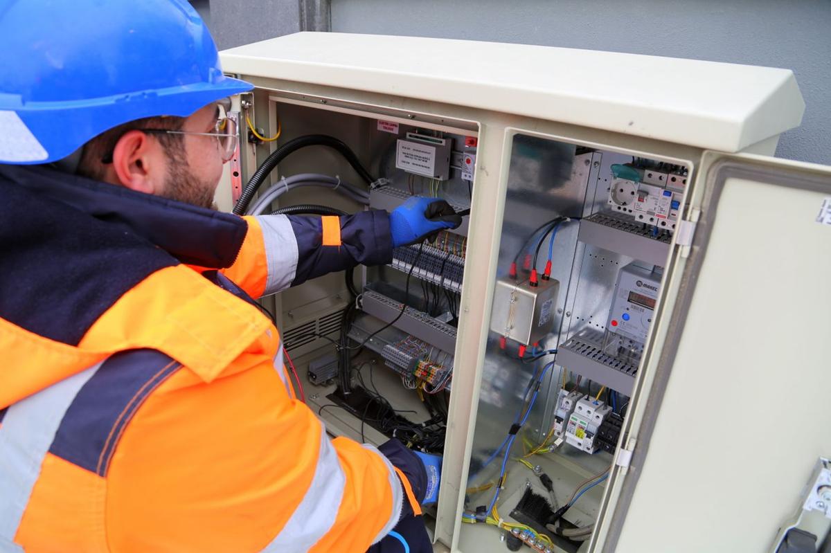 Elektriker arbeitet an einem Sicherungskasten